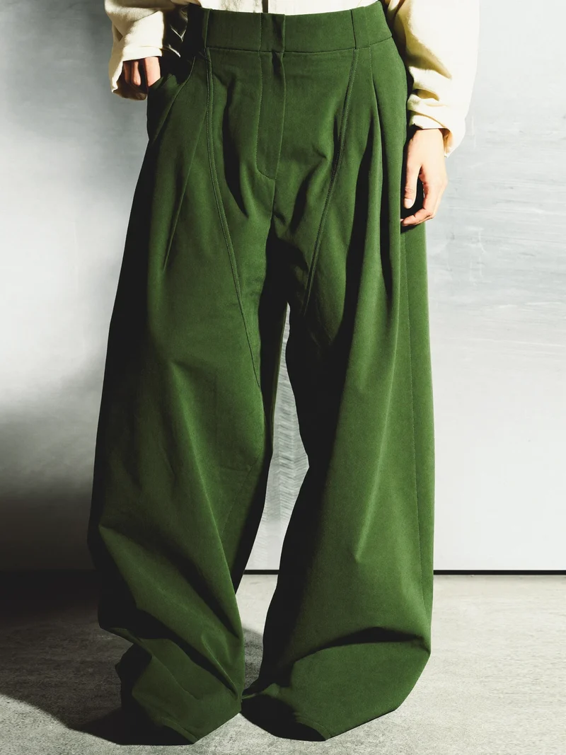 Studio illustrato dei pantaloni ampi plissettati con cuciture curve